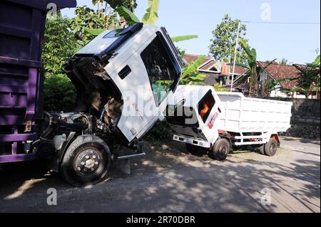 10 giugno 2023, Kulonprogo, Yogyakarta, Indonesia: Un camion passa davanti a un camion reale in un villaggio di un residente a Kulonprogo, Yogyakarta, il 12 giugno 2023. Il carrello utilizza un motore motociclistico modificato. Il carrello giocattolo ha un design simile a quello di un camion in generale, ma ha dimensioni molto più piccole con funzioni di avanzamento, arretramento e sollevamento dietro il letto. Un giovane di nome Imam, il proprietario di Rimbono Garage, ha detto che lo scopo di fare il mini camion era inizialmente solo per soddisfare le richieste dei fan sui social media. perché prima di fare macchine giocattolo, il corpo del camion è stato puramente fatto a mano f Foto Stock