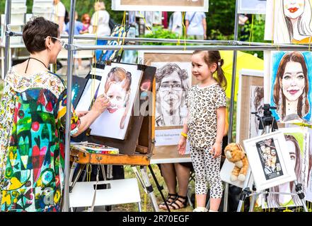 Samara, Russia - 27 maggio 2023: Artista donna dipinge un ritratto di una giovane ragazza su una strada della città durante il vernisage all'aperto Foto Stock