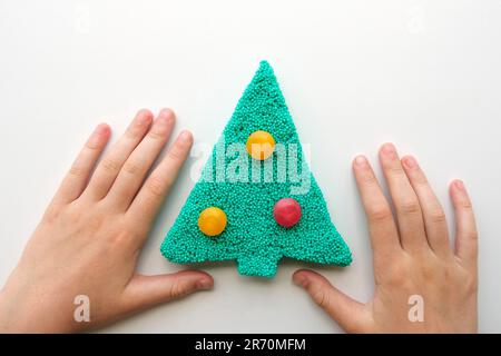 Le mani giocano con il slime testurizzato con le bolle, allungando la sostanza gooey. Mano adolescente femmina che tiene verde brillante slime, schiacciandolo. Adorabile G. Foto Stock