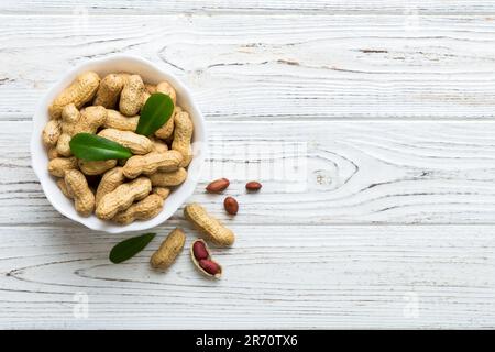 Arachidi fresche e sane in ciotola su sfondo colorato. Vista dall'alto sana alimentazione bertholletia concetto. Super alimenti. Foto Stock