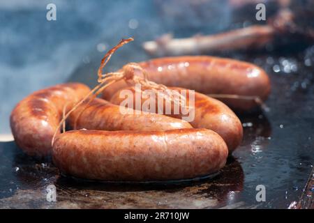 L'Italia, Lombardia, salsiccia di maiale cottura su un barbecue Foto Stock