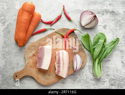 Shanghai bok choy, carote, pancetta di maiale, peperoncini e cipolle disposti sul tavolo. Foto Stock