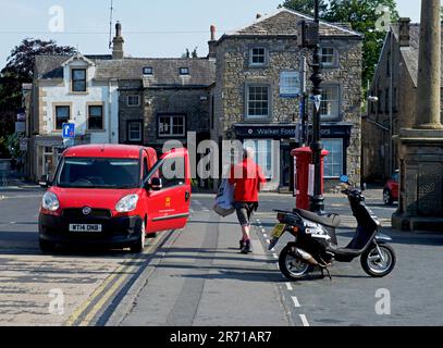 Un postino che raccoglie la posta dalla casella postale di Settle, North Yorkshire, Inghilterra, Regno Unito Foto Stock