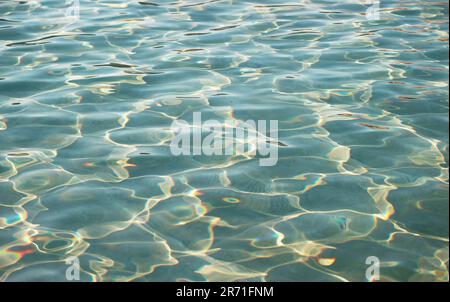 Disegni artistici della superficie dell'acqua nella piscina che si riflettono con la luce del sole Foto Stock