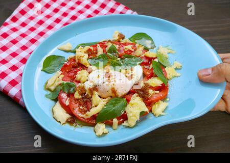 Appetitosa insalata caprese fatta in casa con un uovo in camicia per una sana colazione Foto Stock