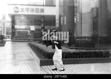 Shanghai Cina 2000. Tifone! Forti piogge e i tifoni occasionali si verificano durante i mesi estivi da giugno ad agosto quando è molto caldo e umido. A causa dei cambiamenti climatici e della posizione riparata di Shanghai i tifoni sono ora piuttosto minimi e non così distruttivi come quelli sperimentati da Hong Kong o Taiwan. Settembre e ottobre sono considerati i mesi migliori a Shanghai, mentre gli inverni sono simili a quelli nel sud dell'Inghilterra, che può sembrare sorprendente dato che la città è sulla stessa latitudine del Cairo. 2000s OMERO SYKES Foto Stock