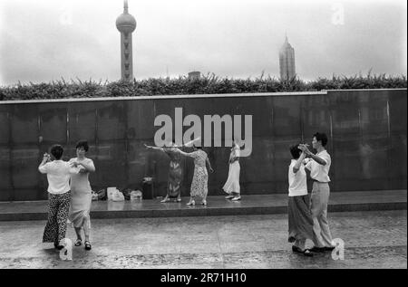 Shanghai Cina 2000. Una lezione di ballo di prima mattina sul Bund sullo sfondo della torre Oriental Pearl TV e dell'edificio Jin Mao. La danza da ballo divenne popolare durante gli anni '1980s come forma di esercizio fisico o di sport agonistico, non l'attività sociale che era originariamente. Shanghai. La Repubblica popolare Cinese. 2000s OMERO SYKES Foto Stock