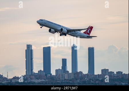 Un Airbus A321 di volo commerciale Turkish Airlines vola sopra i grattacieli dello skyline di Madrid, conosciuta come la "zona commerciale delle quattro torri", dopo la de Foto Stock