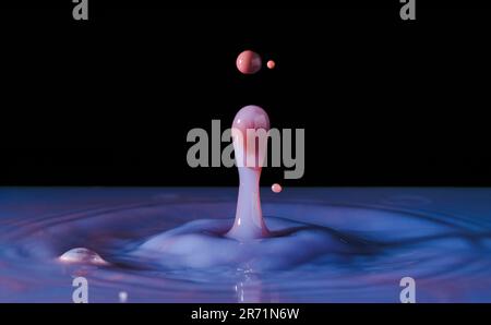 Primo piano macrofotografia di gocce d'acqua viola rossa e rosa congelate nella fotografia ad alta velocità Foto Stock