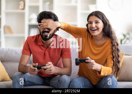Coppia indiana allegra divertirsi a casa, giocare insieme ai videogiochi Foto Stock