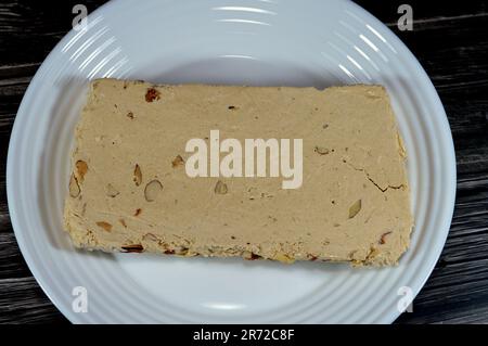 Tradizionale tahini halva con mandorle o Halawa Tahiniya, gli ingredienti principali di questa confezione sono burro di sesamo o pasta (tahini), e zucchero, g Foto Stock
