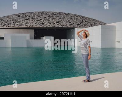 Abu Dhabi, Emirati Arabi Uniti - 21 marzo 2023 : viaggiatore femminile vicino al museo del Louvre ad Abu Dhabi, Emirati Arabi Uniti. Il Louvre è un nuovo museo negli Emirati Arabi Uniti aperto il 8th 2017 novembre Foto Stock