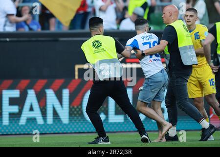 12 giugno 2023, Brema: Calcio: Internazionale, Germania - Ucraina, a wohninvest Weserstadion. Le guardie di sicurezza conducono uno streaker fuori dal campo. NOTA IMPORTANTE: In conformità ai requisiti della DFL Deutsche Fußball Liga e del DFB Deutscher Fußball-Bund, è vietato utilizzare o utilizzare fotografie scattate nello stadio e/o della partita sotto forma di immagini in sequenza e/o serie di foto simili a video.NOTA IMPORTANTE: In conformità ai requisiti della DFL Deutsche Fußball Liga e/o della DFB Deutscher Fußball-Bund, è vietato utilizzare o utilizzare fotografie scattate in Foto Stock