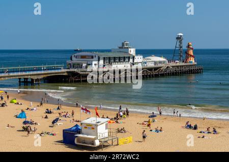 Bournemouth, Regno Unito - Giugno 5th 2023: Persone intorno alla torre del bagnino RNLI sulla spiaggia di fronte al molo di Bournemouth. Foto Stock