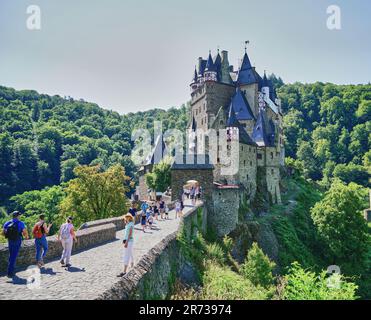 Fiabesco Burg Eltz Castello con i turisti a piedi il sentiero in pietra ingresso e porta ad arco. Valle del fiume Mosella zona della Germania. Foto Stock