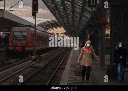 Foto delle donne che aspettano un treno sulle piattaforme della stazione ferroviaria di Koln hauptbahnhof, indossando maschere facciali durante il Coronavirus Covid 19 Health cr Foto Stock