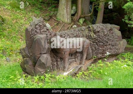 Banska Stiavnica, Slovacchia - 11 giugno 2023 : statua di lupo in legno intagliato nel parco. Decorazione del giardino. Scultura. Foto Stock