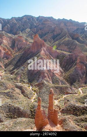 Paio di natura sculture in Danxia Binggou Canyon rilievi in Zhangye, Sunan Regione, Provincia di Gansu, Cina. Pietra arenaria rossa rocce del Geoparco. Rosso Foto Stock