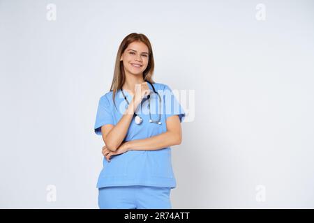 Ritratto di donna sorridente medico in cappotto blu in piedi isolato su sfondo bianco. Foto Stock