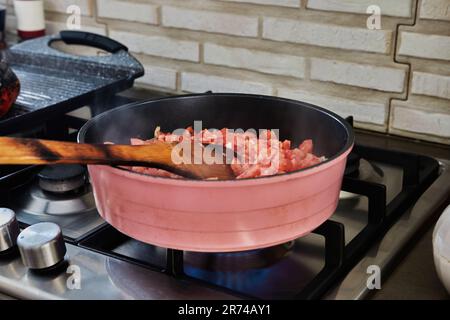 Mescolato pomodori tritati in pentola con ingredienti su stufa a gas Foto Stock