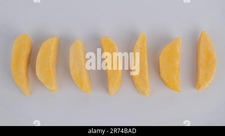 Frutta secca congelata sana. Pezzi di mango con processo liofilizzato isolato su fondo bianco. Foto Stock