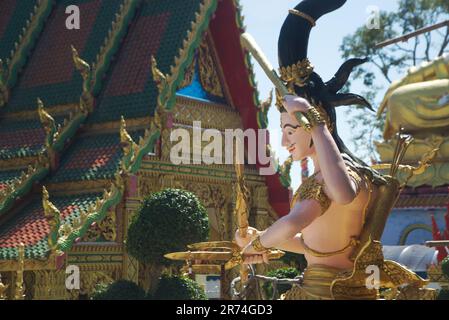 Retro della chiesa buddista e statua di Angelo custode nel tempio di Wat Maniwong. Foto Stock