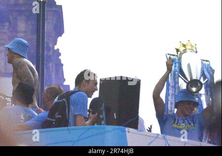 Manchester, Regno Unito. 12th giugno, 2023. La tazza è tenuta alta sul bus aperto superiore. La festa della parata di vittoria dell'autobus aperto in cima alla cima nel centro di Manchester, Regno Unito, per segnare il successo del loro club che vince gli alti: La Premier League, la fa Cup e la Champions League. Il sabato Man City ha battuto l'Inter Milan a Istanbul per assicurarsi la vittoria della Champions League. La sfilata di autobus scoperti passava per il centro di Manchester, sotto la vista di grandi folle entusiaste, nonostante la tempesta e la pioggia intensa. Credit: Terry Waller/Alamy Live News Foto Stock