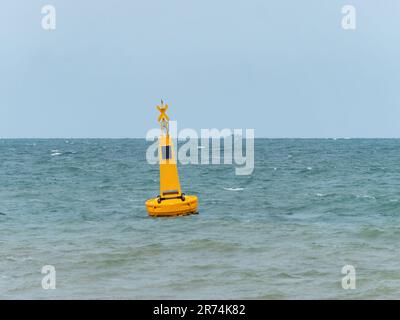 Boa gialla con luce solare in mare per segnalare un'area pericolosa, in questo caso un'area riservata ai nuotatori nei pressi di una spiaggia a Pattaya, Thailandia. Foto Stock