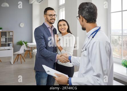 Felice coppia incontro medico specialista famiglia in ufficio Foto Stock