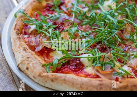 gustosa pizza appena sfornata su un tavolo di legno Foto Stock
