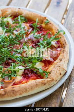 gustosa pizza appena sfornata su un tavolo di legno Foto Stock