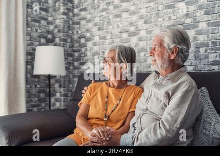 Felice marito e moglie si siedono riposo sul divano a casa abbracciando e coccolando, mostrare affetto cura, sorridente coppia amante senior rilassarsi sul divano divertirsi, godersi un romantico fine settimana in famiglia insieme Foto Stock