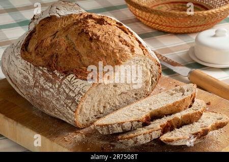 Pane fresco e fette di pasta madre contadini pane primo piano su un tagliere Foto Stock