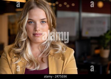 Ritratto di donna d'affari caucasica Happy Plus size con lunghi capelli biondi in ufficio Foto Stock
