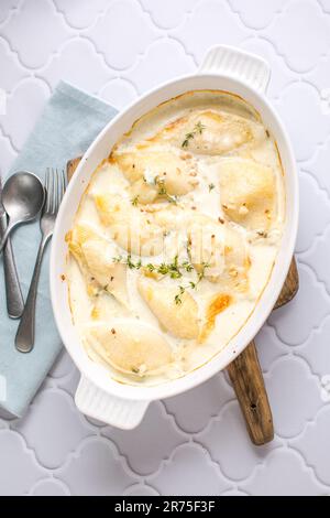 pasta di pollo e conchiglie cheesy e cremosa cuocere in teglia da forno su un tavolo di cemento grigio scuro, vista orizzontale dall'alto, primo piano Foto Stock