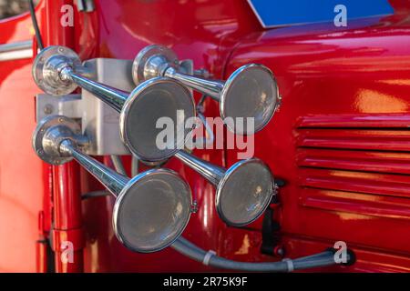 Quattro avvisatori acustici vintage su uno storico camion dei pompieri. Primo piano. Foto Stock