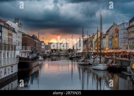 Il tramonto, le nuvole di pioggia su Nyhavn con le sue case colorate, è considerato il punto di vista più importante a Copenhagen, Danimarca Foto Stock