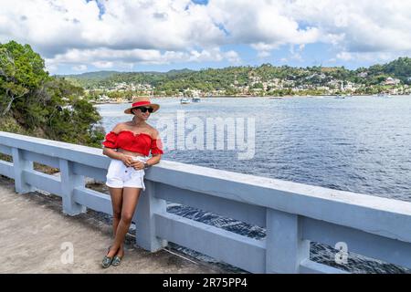 Nord America, Caraibi, grandi Antille, Isola di Hispaniola, Repubblica Dominicana, Provincia di Sama, Penisola di Sama, Santa rbara de Sama, Pretty Latina appoggiata sulla ringhiera del ponte nella Baia di Sama Foto Stock