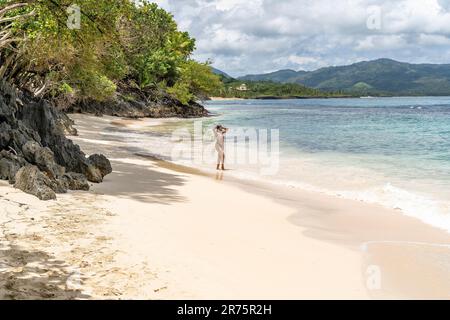 Nord America, Caraibi, grandi Antille, Isola di Hispaniola, Repubblica Dominicana, Provincia di Sama, Penisola di Sama, Las Galeras, Playa Caletón, attraente Latina dalla pelle scura che sorge sulla spiaggia bianca di Playa Caletón Foto Stock