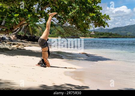 Nord America, Caraibi, grandi Antille, Isola di Hispaniola, Repubblica Dominicana, Provincia di Sama, Penisola di Sama, Las Galeras, Playa Escondida, attraente Latina fa yoga sulla pittoresca spiaggia di Playa Escondida Foto Stock