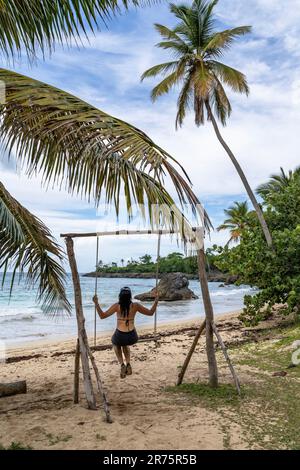 Nord America, Caraibi, grandi Antille, Isola di Hispaniola, Repubblica Dominicana, Provincia di Sama, Penisola di Sama, Las Galeras, Playa Breman, donna attraente su un altalena sulla spiaggia Foto Stock