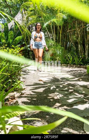 Nord America, Caraibi, grandi Antille, Isola di Hispaniola, Repubblica Dominicana, Costa del Nord, Provincia di Puerto Plata, Cabarete, attraente Latina cammina un sentiero nel Boutique Hotel natura Cabana lungo Foto Stock