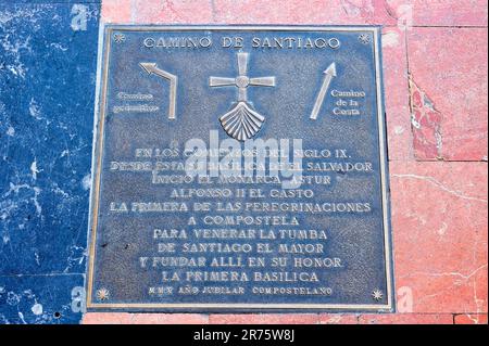 Oviedo, Asturie, Spagna - 12 febbraio 2023: Una targa di piastrelle quadrate che legge Camino de Santiago. Presenta testo, frecce e una croce religiosa. Foto Stock