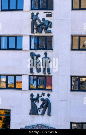 Oviedo, Asturie, Spagna - 12 febbraio 2023: Murale di lavoro di Goico-Aguirre. Un edificio con pareti dipinte di blu che mostra sculture in rilievo. Foto Stock