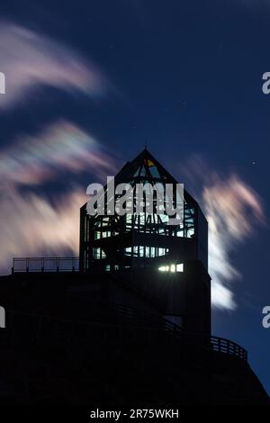 Wilhelm Swarovski Observatory in una notte di luna piena, la luna splende attraverso la torre, le nuvole iridescenti del velo nel cielo Foto Stock