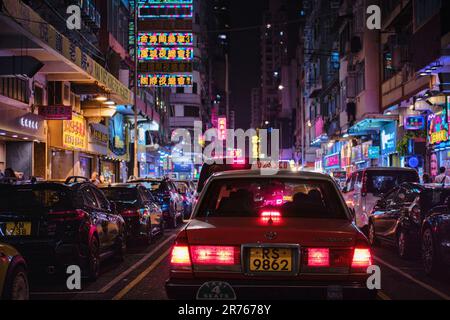 Mong Kok, Hong Kong - Aprile 12 2023: Un Taxi tradizionale rosso e colorati segnali luminosi al neon Foto Stock