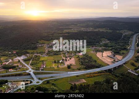 Vista dall'alto veduta aerea dall'alto dei punti di uscita della rotonda per i veicoli autostradali per evitare di attraversare il traffico e circondato da verde agricolo Foto Stock