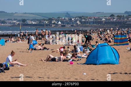 Portobello, Edimburgo, Scozia, Regno Unito. 13 giugno 2023. Il caldo è sulla spiaggia porty e sul lungomare per le folle miste fuori nel tardo pomeriggio dopo un altro inizio misteriosa della giornata. Temperatura 21 gradi centigradi con un po' di brezza fresca. Persone di tutte le età possono rilassarsi al sole sulla spiaggia di sabbia. Credit: Arch White/alamy live news. Foto Stock