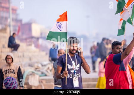 Varanasi, India - novembre 2022: Ganga aarti, Ritratto di un giovane maschio che detiene bandiera indiana mentre partecipa a ganga aarti a kedar ghat a varanasi. Foto Stock