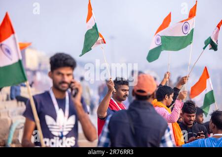 Varanasi, India - novembre 2022: Ganga aarti, Ritratto di un giovane maschio che detiene bandiera indiana mentre partecipa a ganga aarti a kedar ghat a varanasi. Foto Stock